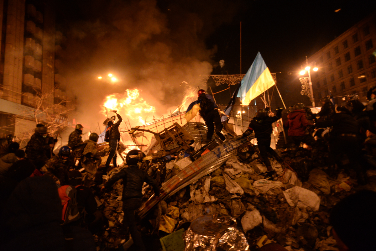 SState flag of Ukraine carried by a protester to the heart of developing clashes in Kyiv, Ukraine. Events of February 18, 2014.
